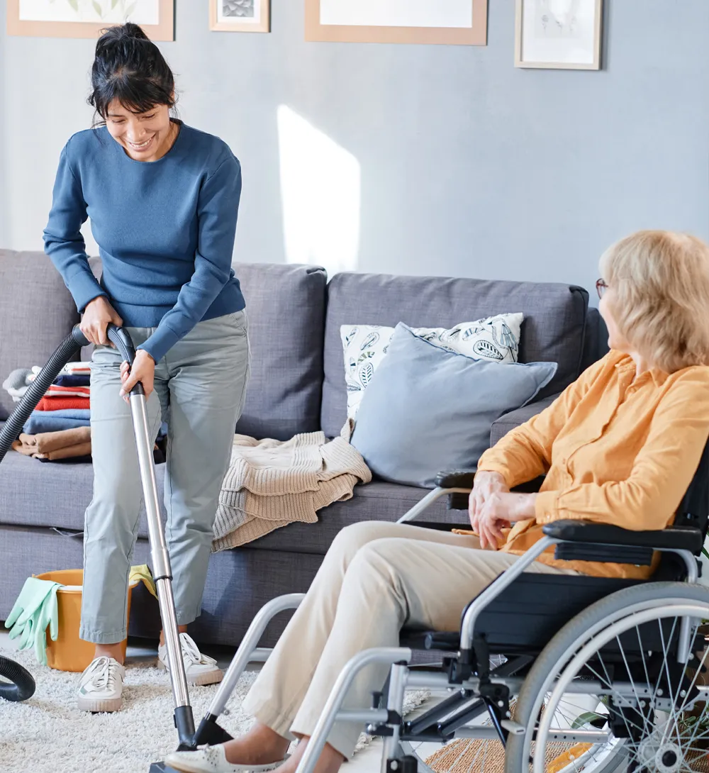NDIS support worker cleaning living room floor in Gold Coast home